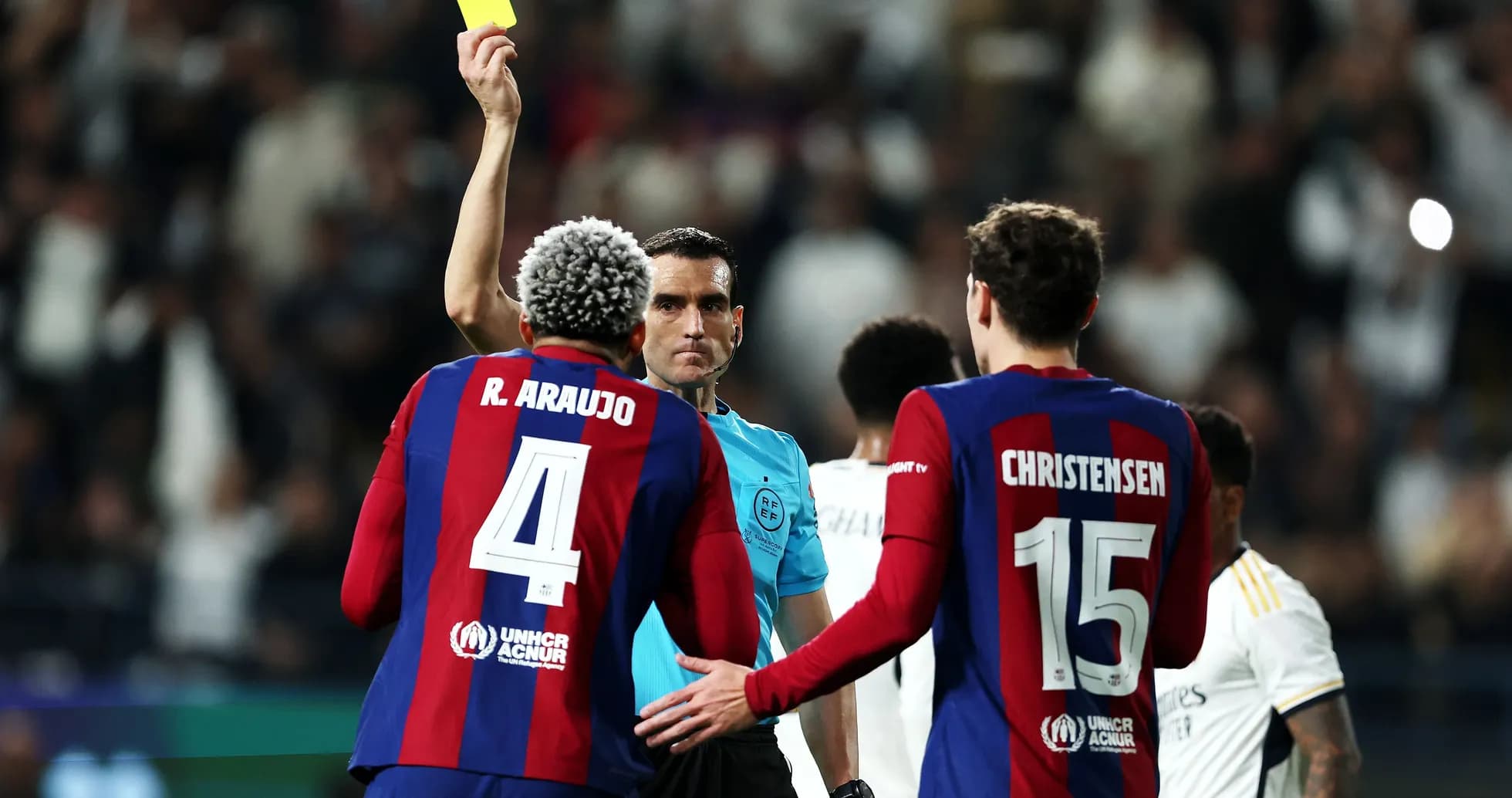 Referee showing yellow card to Barcelona player