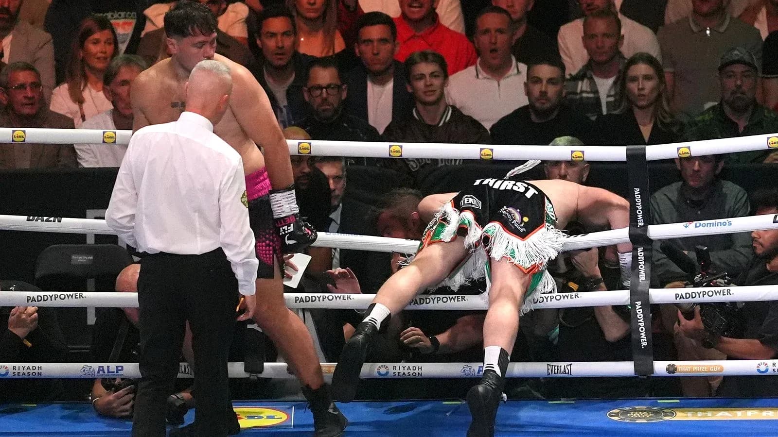 Boxer falling over the ropes during a match