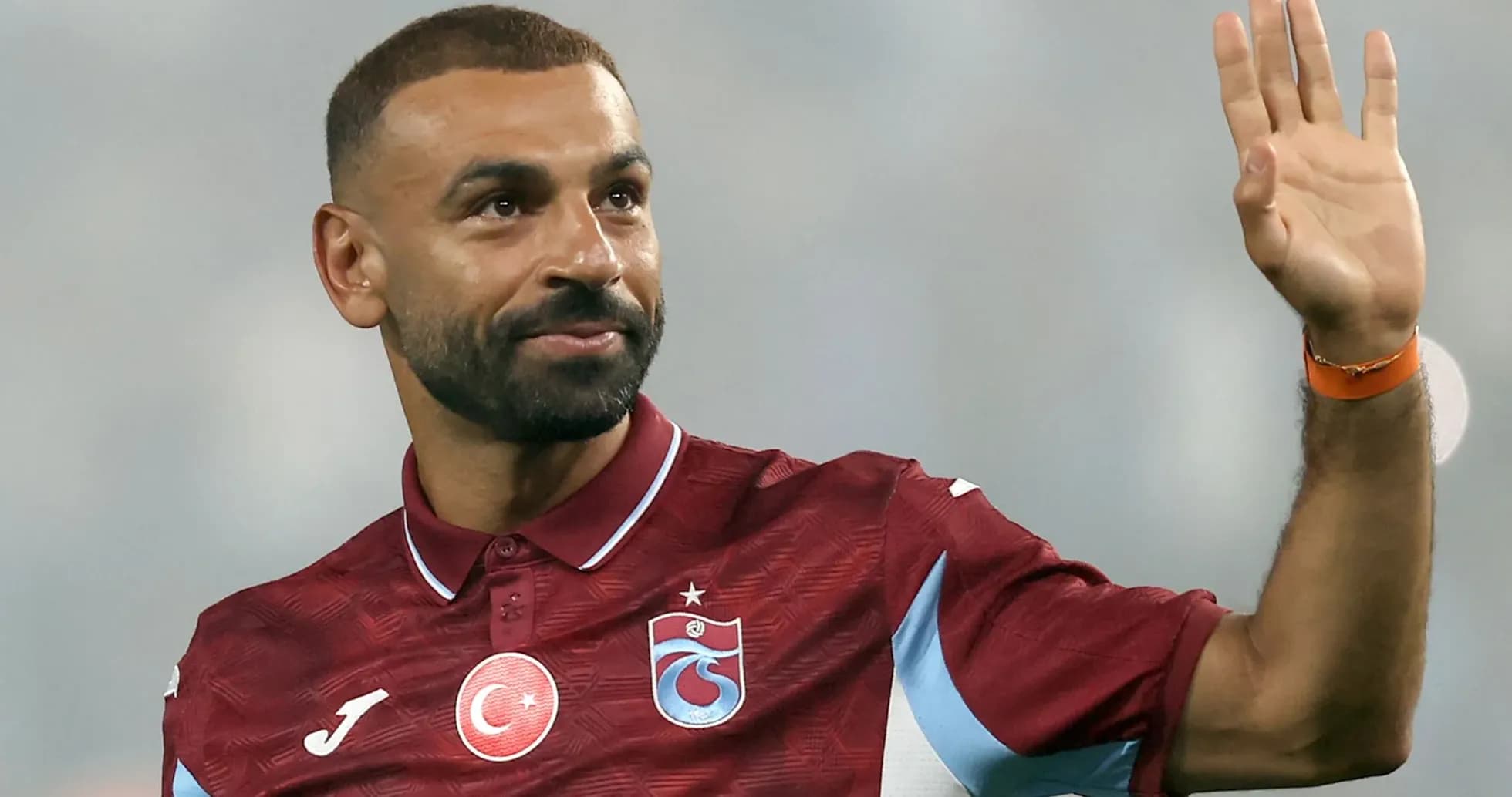Player waving while wearing Trabzonspor jersey