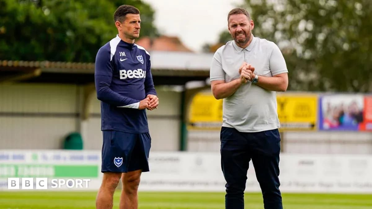 Two coaches discussing on the training pitch