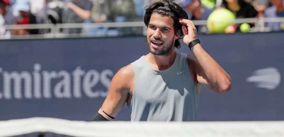 Tennis player adjusting hair during match
