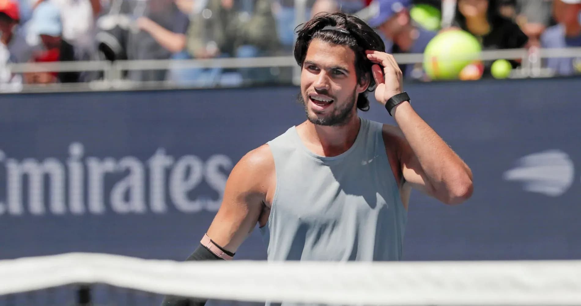 Tennis player adjusting hair during match