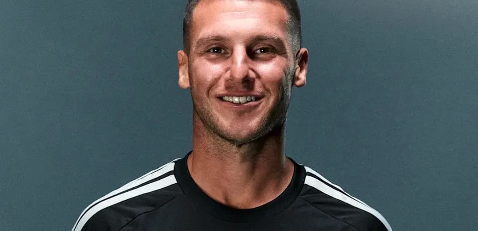 Player smiling in black team jersey with logo