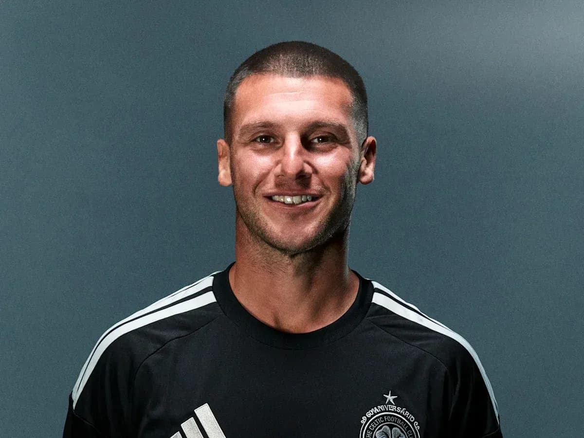 Player smiling in black team jersey with logo
