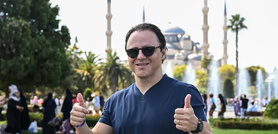 Person giving thumbs up in front of mosque