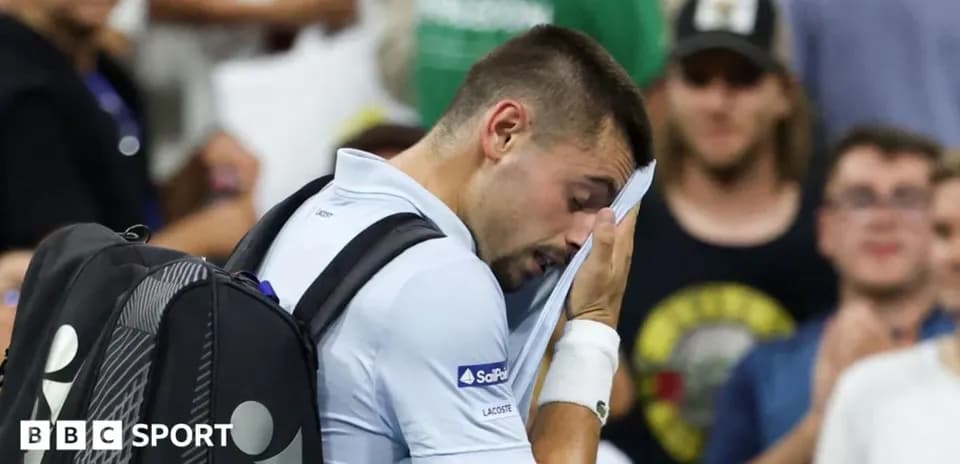 Tennis player wiping sweat during match
