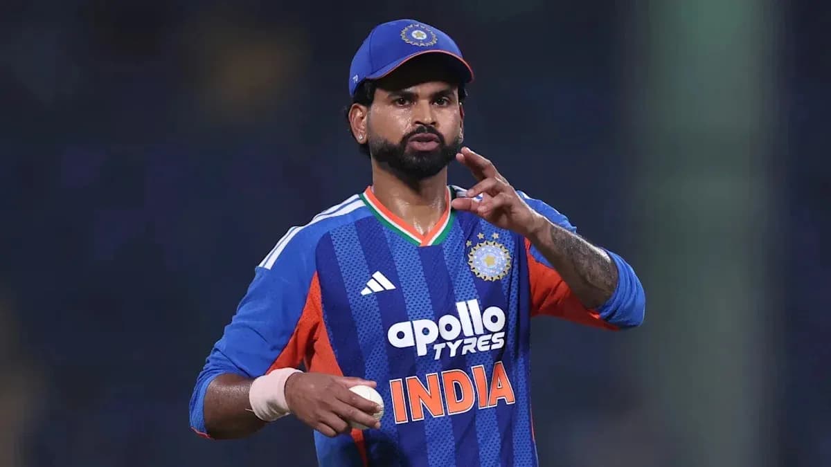 Cricketer gesturing while holding a ball on field