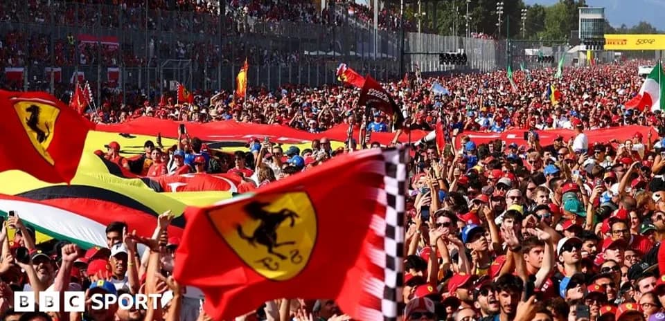 Crowd of fans waving Ferrari flags at event