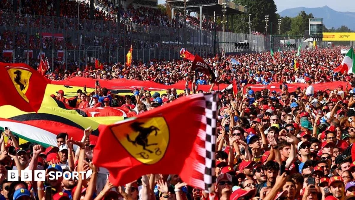 Crowd of fans waving Ferrari flags at event