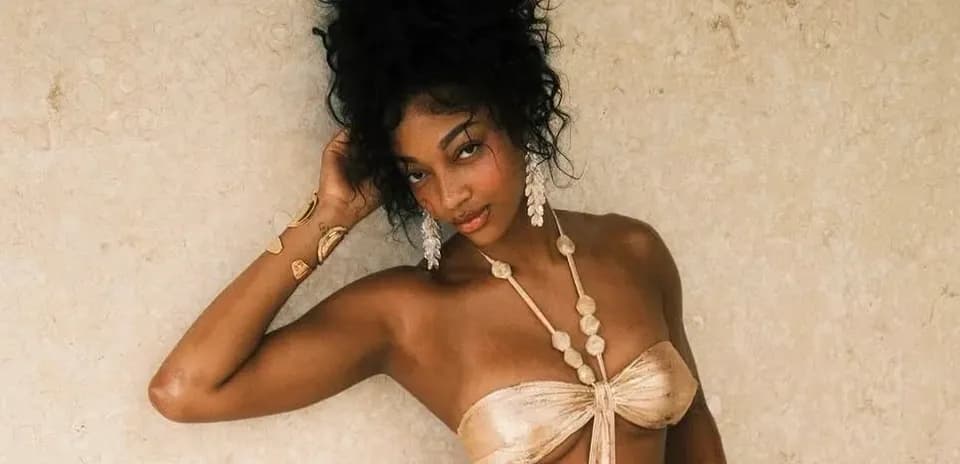 Model posing against a textured beige background