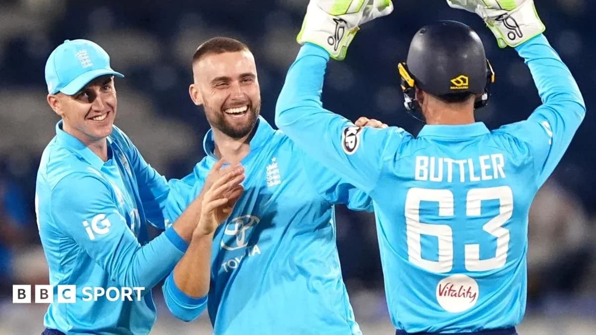 Three England players celebrating a wicket in cricket