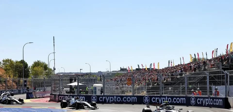 Formula 1 cars racing at a crowded circuit