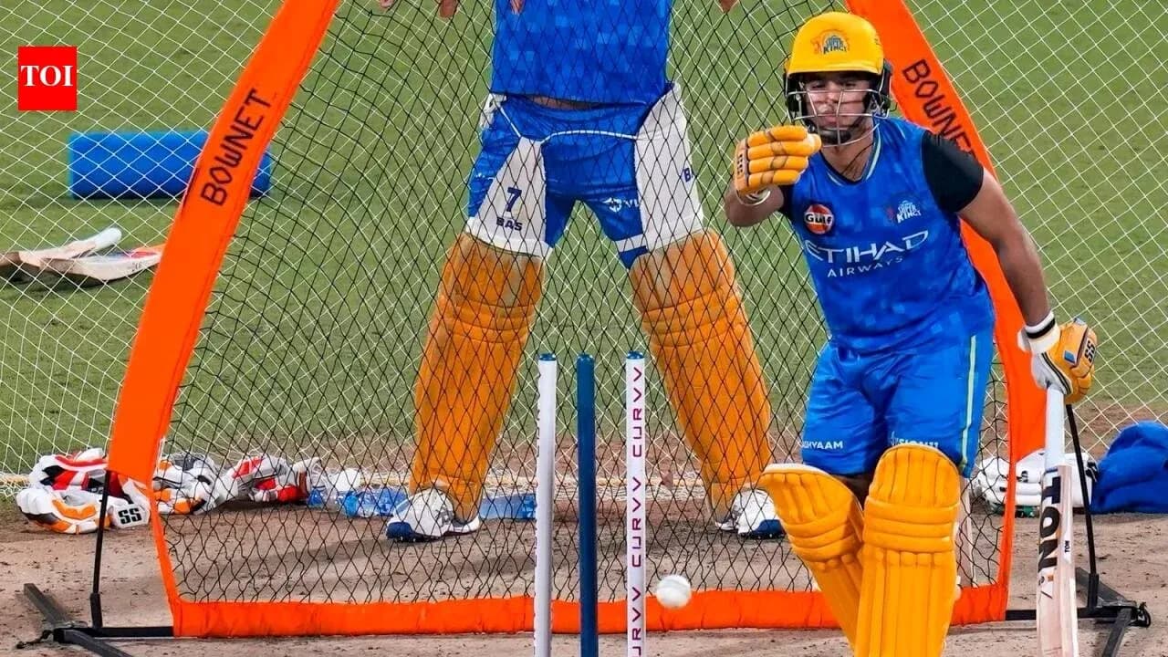 Batsman practicing in nets with wicketkeeper behind