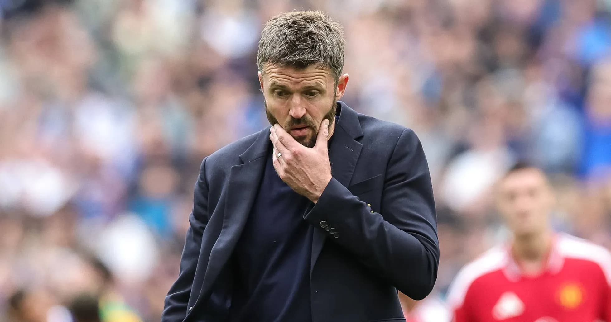 Coach contemplating during a match on the sidelines