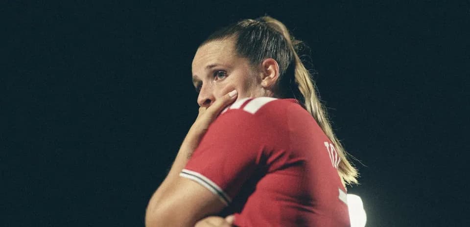 Player in red jersey looking thoughtful during match