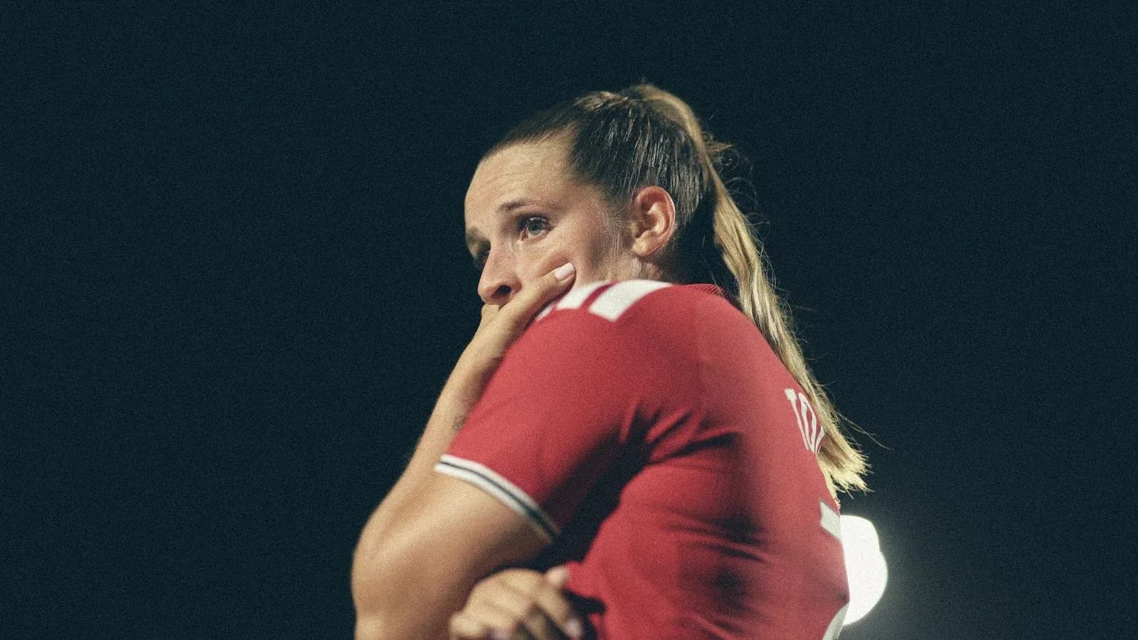 Player in red jersey looking thoughtful during match