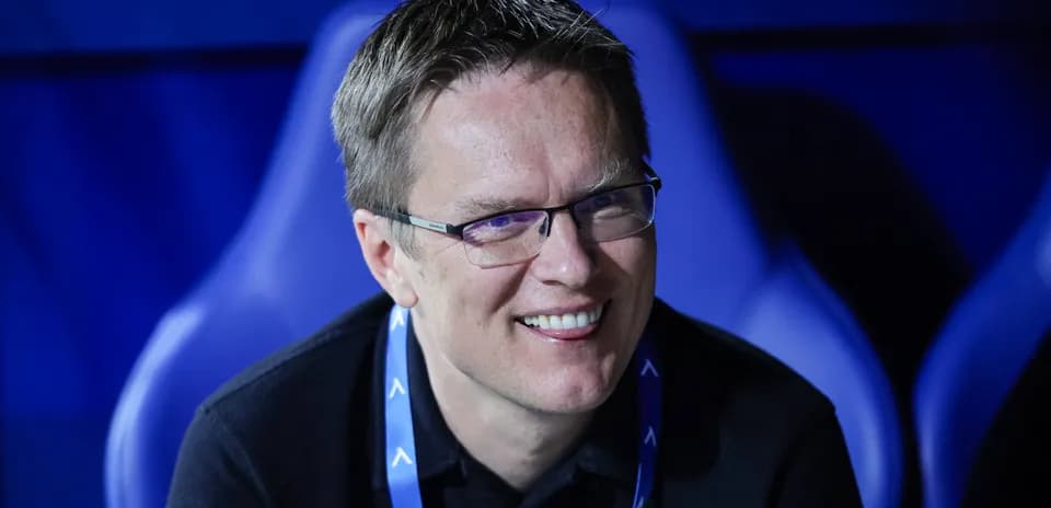 Man smiling while seated in a sports venue