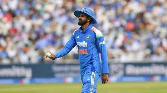 Cricketer in blue jersey holding a cricket ball