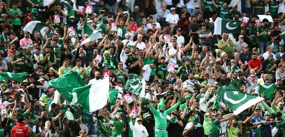 Pakistan cricket fans cheering with flags in stadium