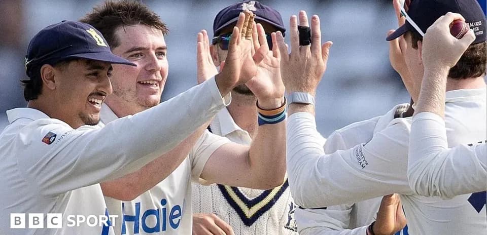 Cricket players celebrating a wicket on the field