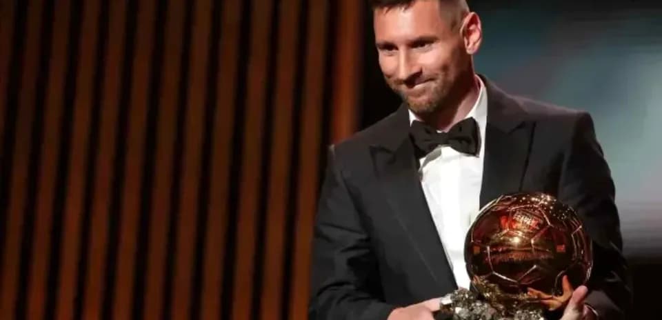 Lionel Messi holding Ballon d'Or award on stage