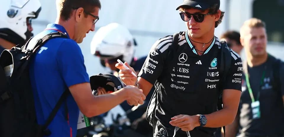 Driver signing autographs in the paddock area