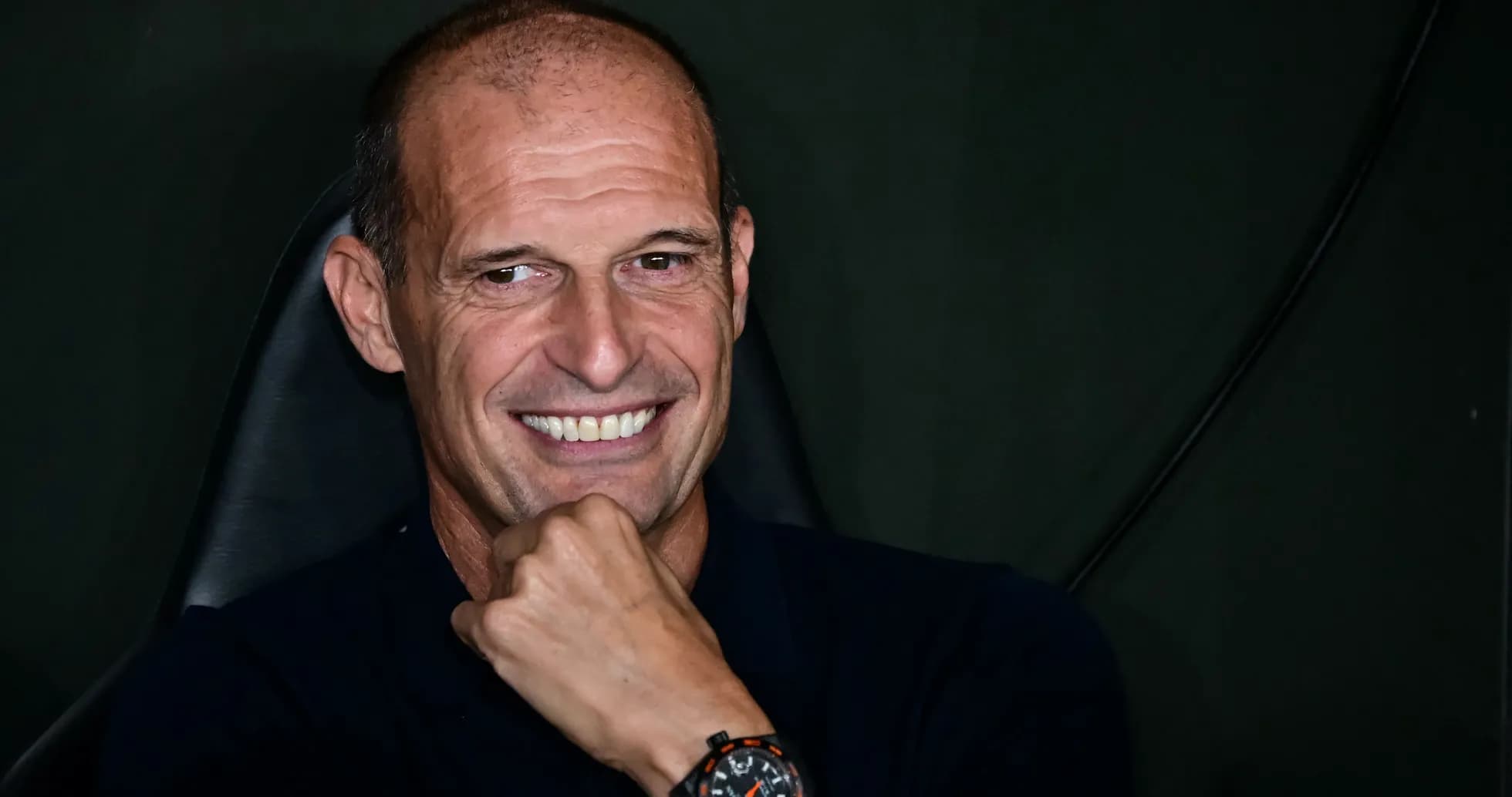 Coach smiling while seated in a chair