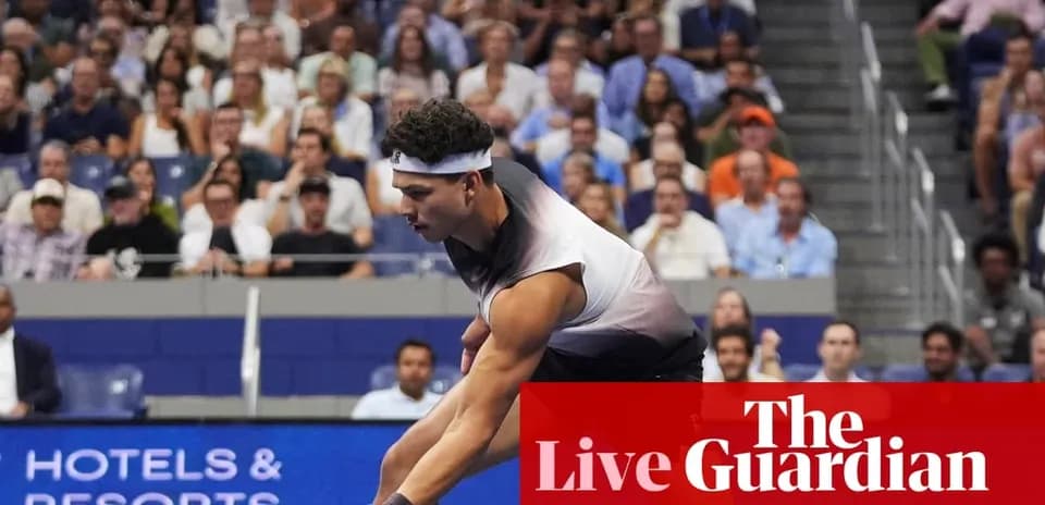 Player serving during a tennis match with crowd behind