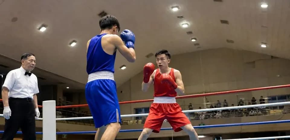 Two boxers sparring in a boxing ring