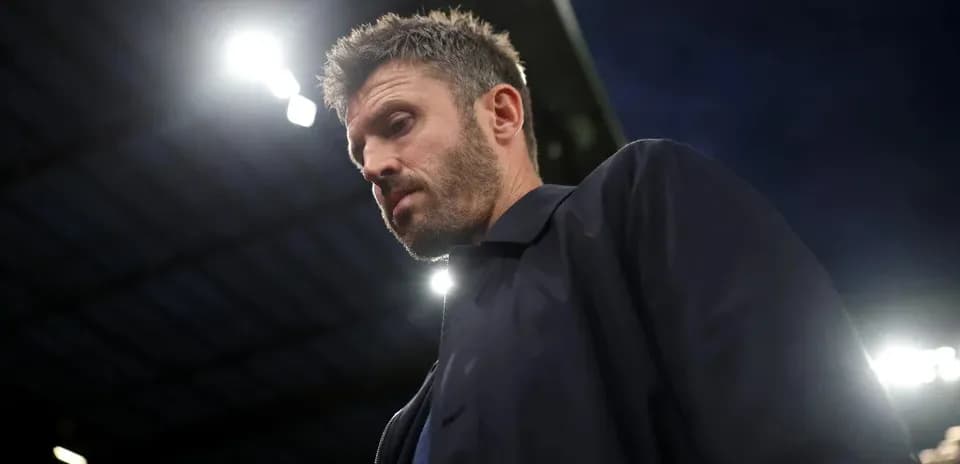 Coach walking under stadium lights during match