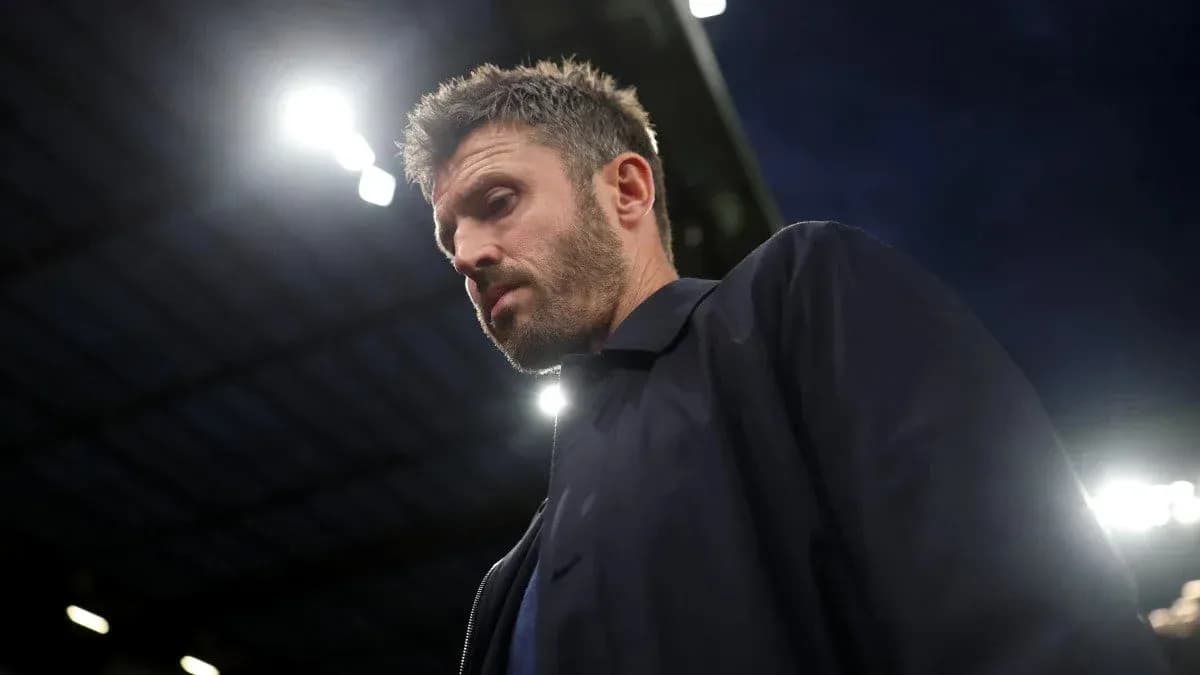 Coach walking under stadium lights during match