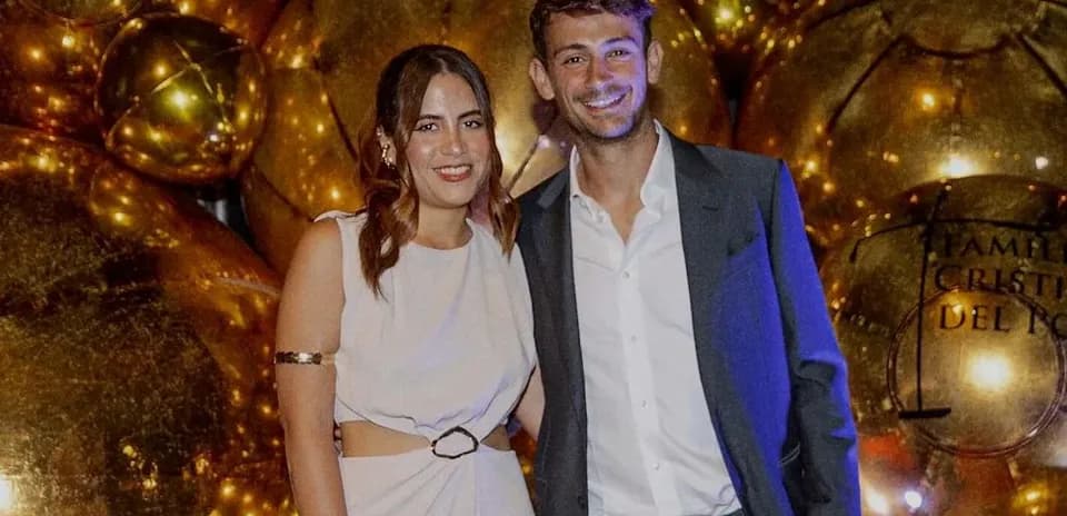 Couple posing at event with golden decorations