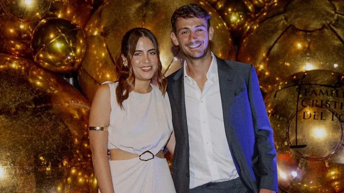 Couple posing at event with golden decorations