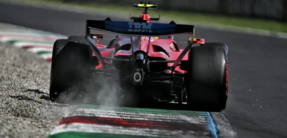 Red Formula 1 car kicking up dust on track