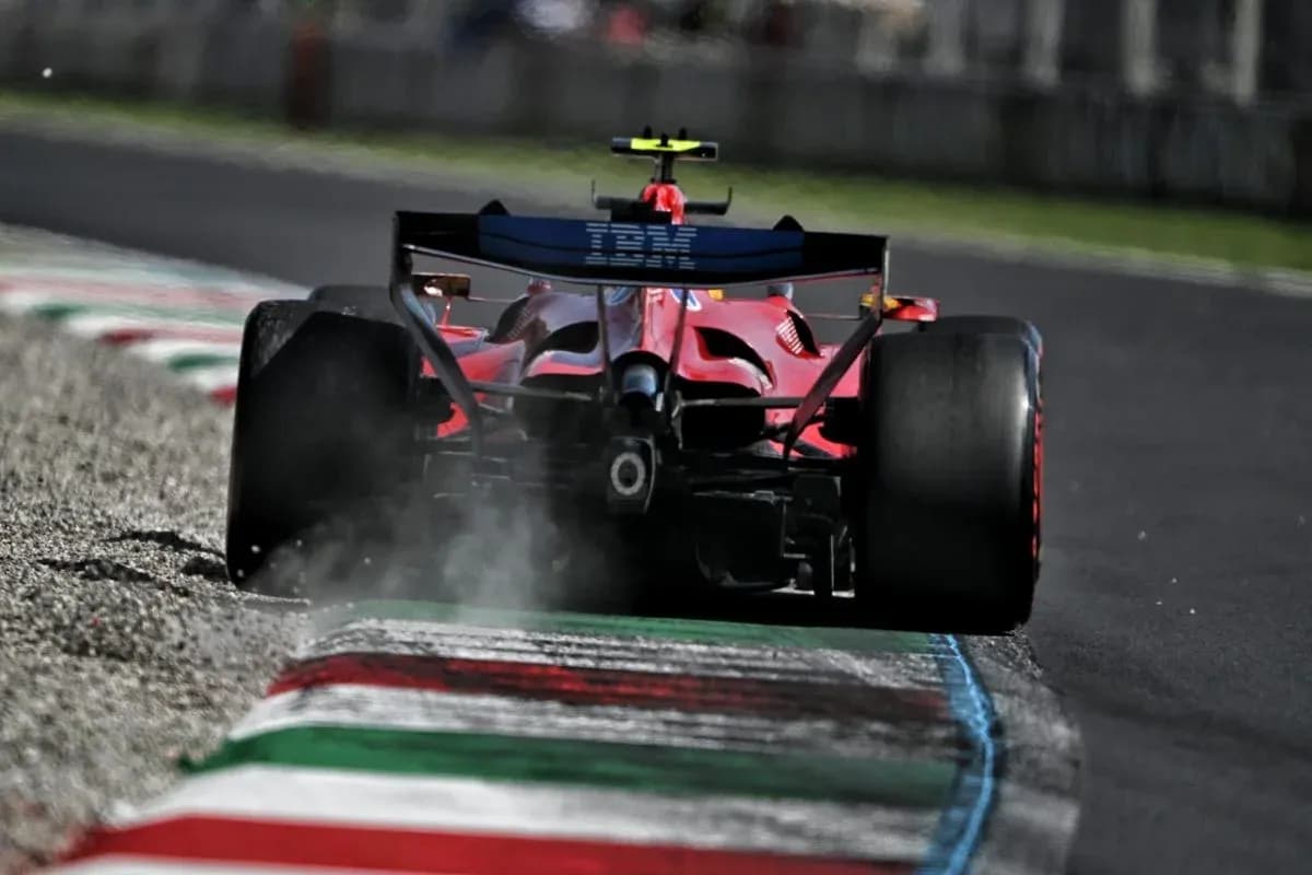 Red Formula 1 car kicking up dust on track
