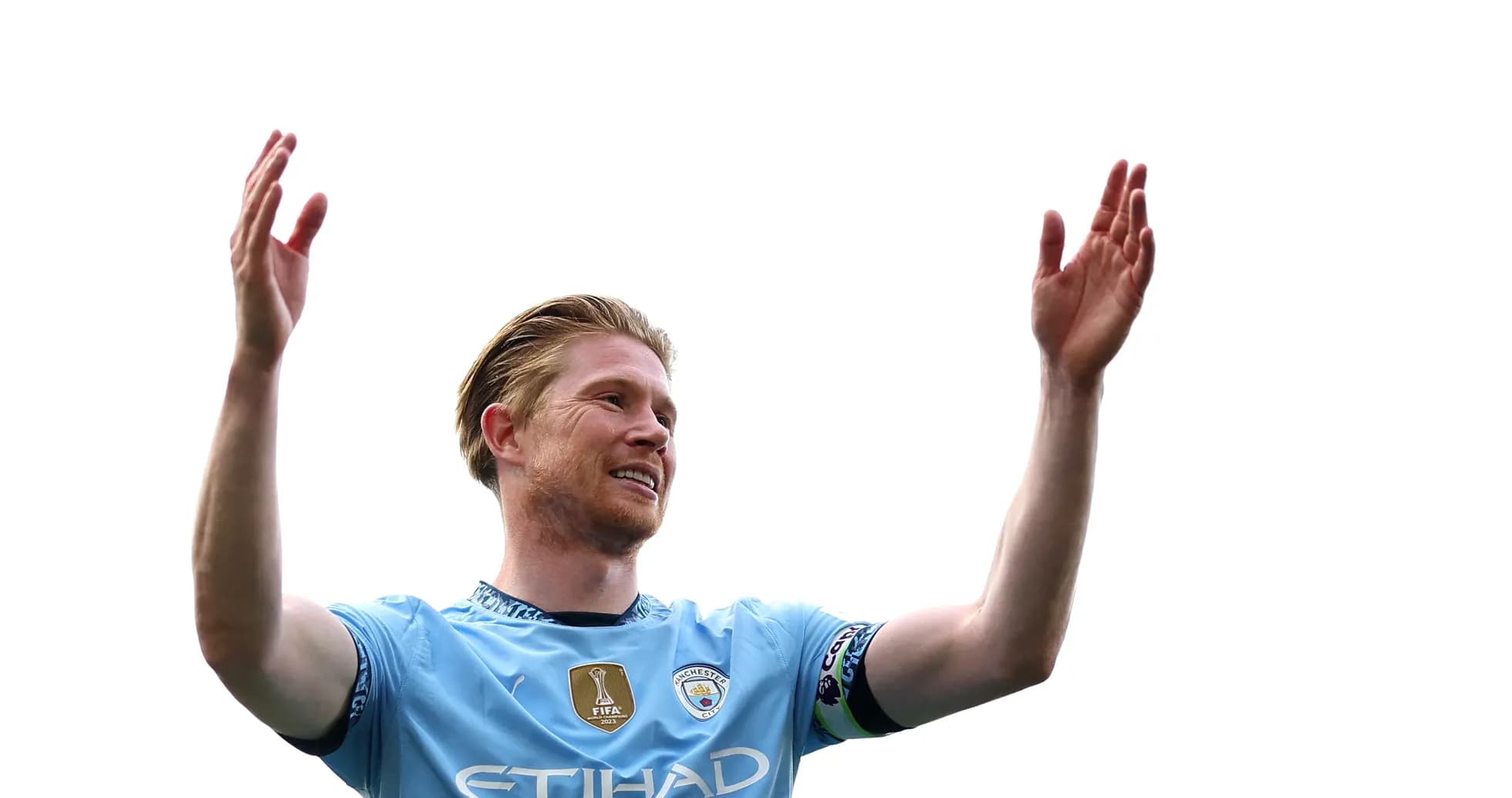 Player celebrating with arms raised in Manchester City jersey