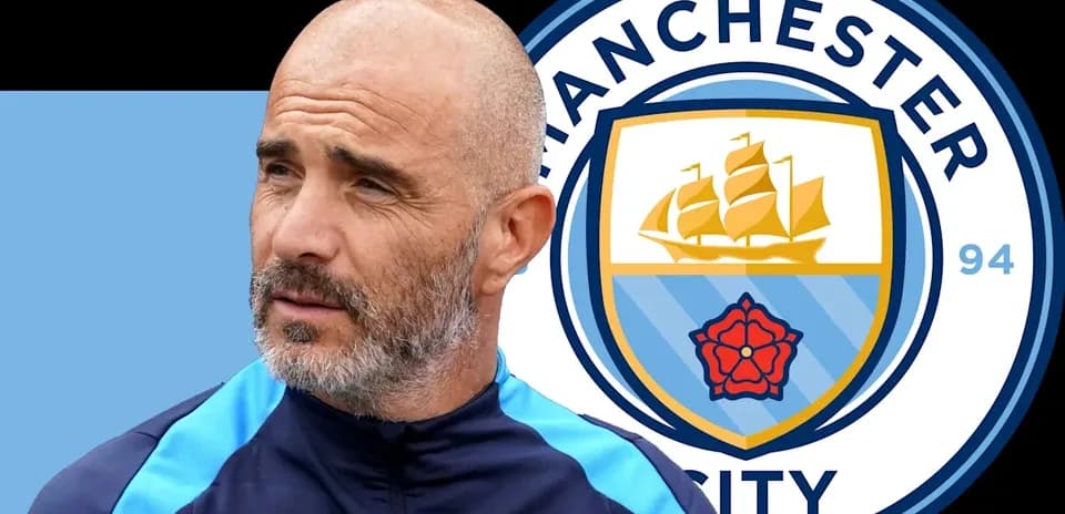 Coach standing next to Manchester City logo backdrop