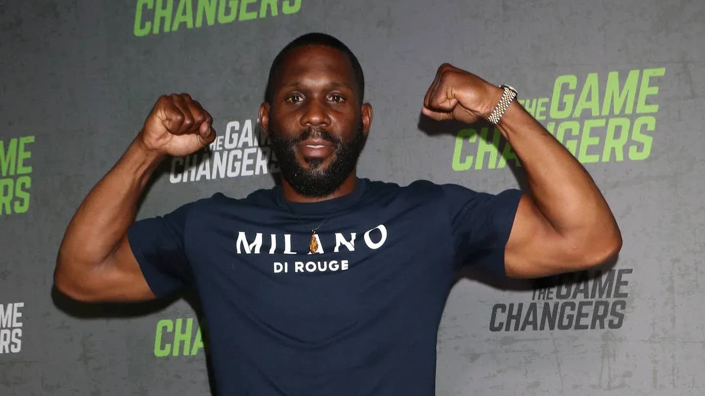 Man flexing muscles at promotional event backdrop
