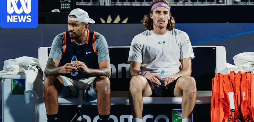 Tennis players seated on bench during match break