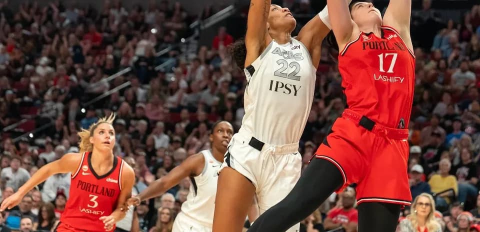 Two players contesting a rebound during basketball game