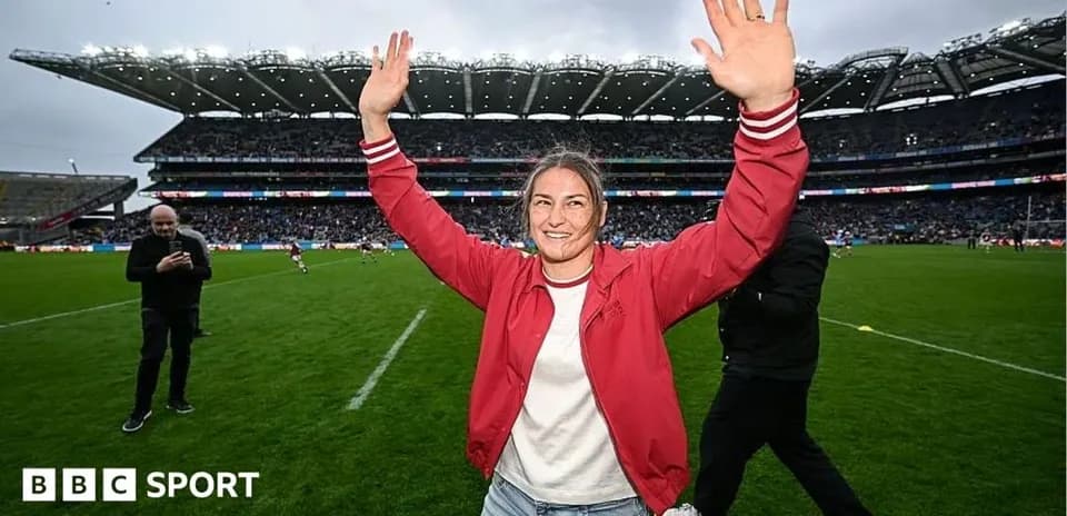 Woman celebrating with hands raised on rugby field