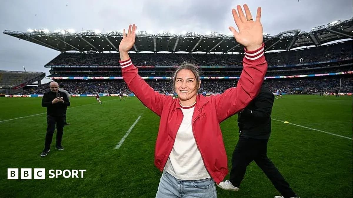 Woman celebrating with hands raised on rugby field