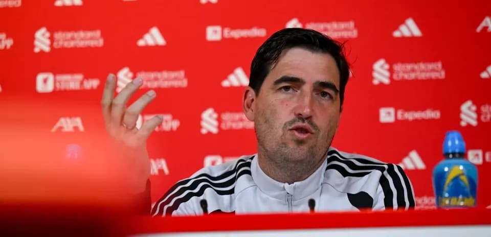 Manager speaking at press conference with branded backdrop