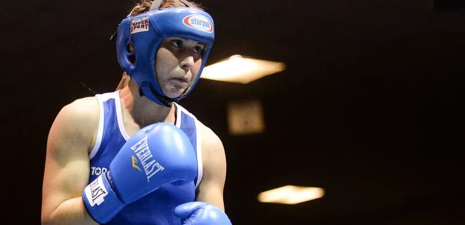 Female boxer in blue gear preparing for match