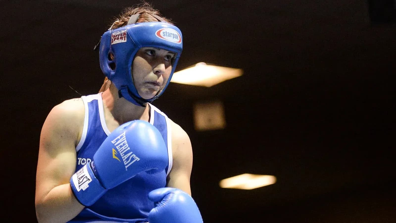 Female boxer in blue gear preparing for match