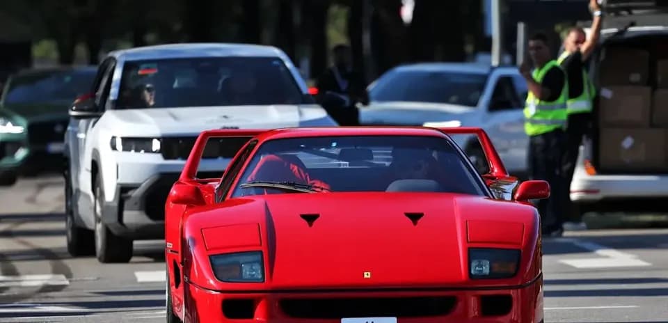 Red Ferrari F40 driving on city street