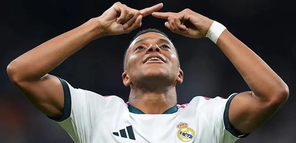 Player celebrating goal with arms raised in stadium