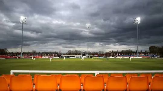 Cricket match in progress under overcast sky