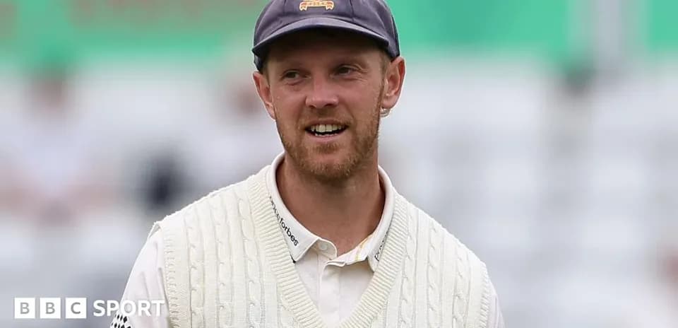 Cricketer wearing a white sweater on field
