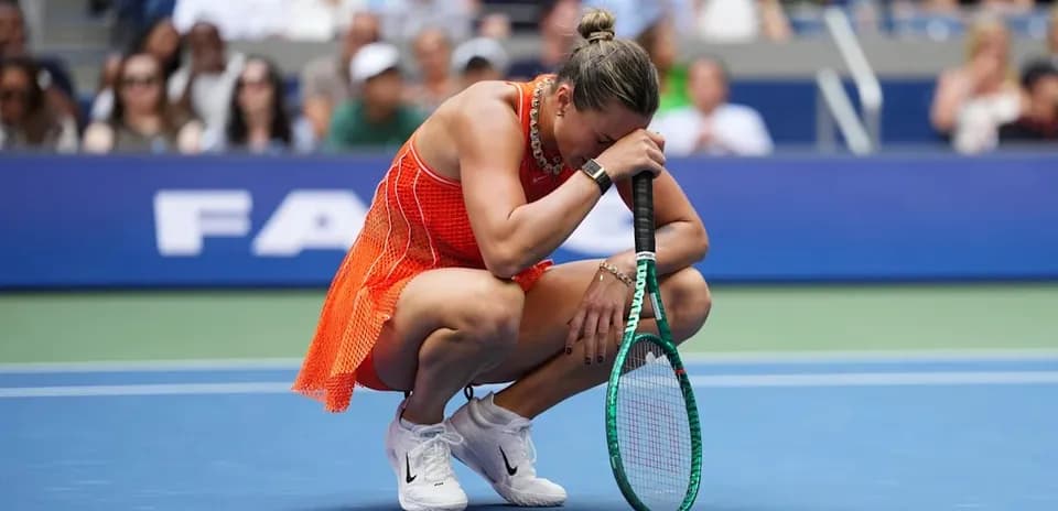 Player kneeling on court, holding racket and head down